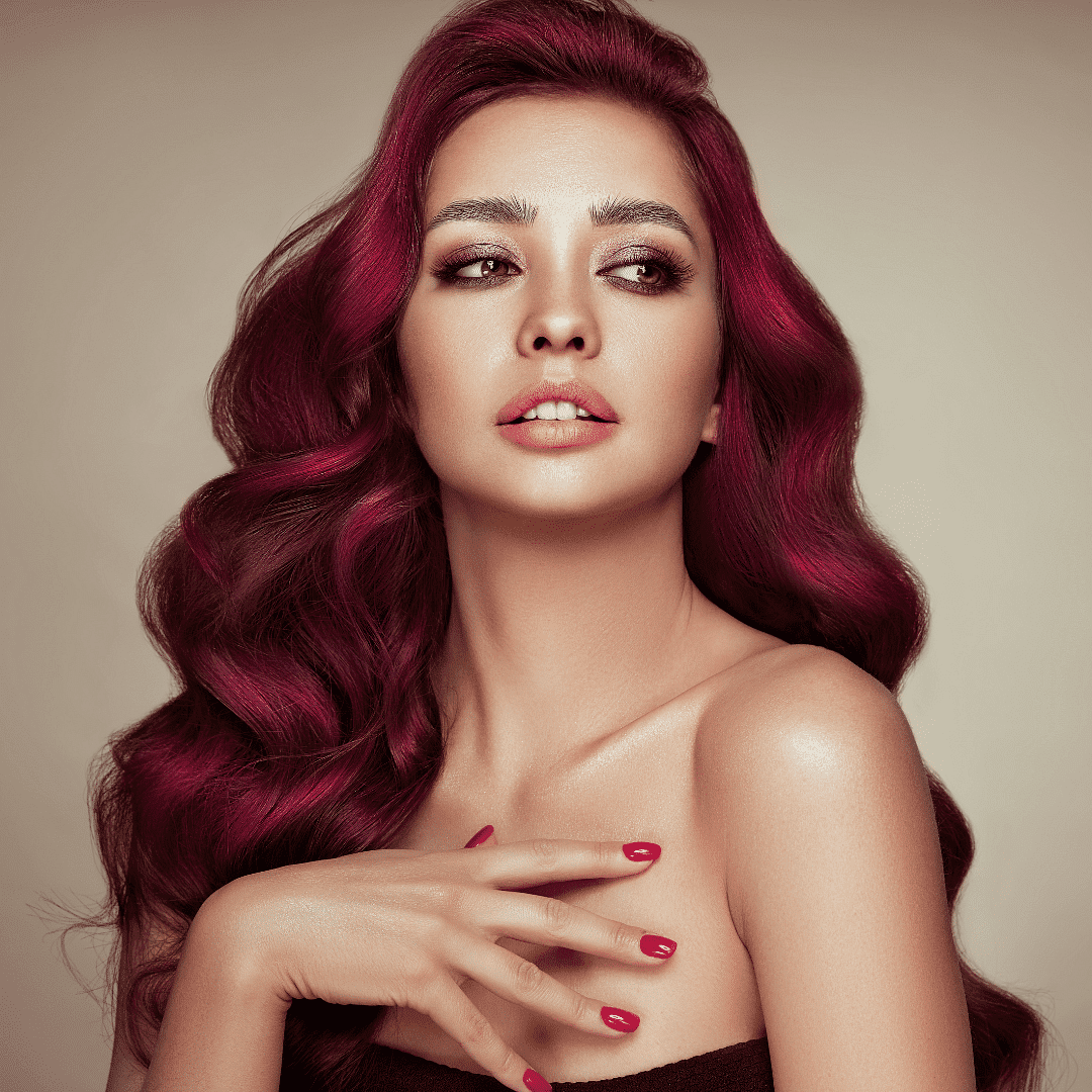 Woman with vibrant red hair posing elegantly.