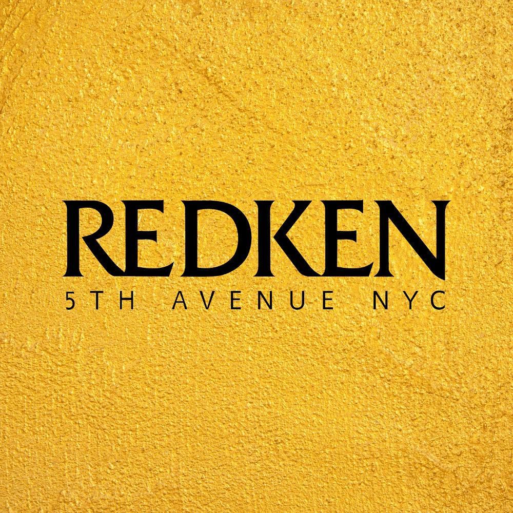 Redken logo on a textured yellow background.